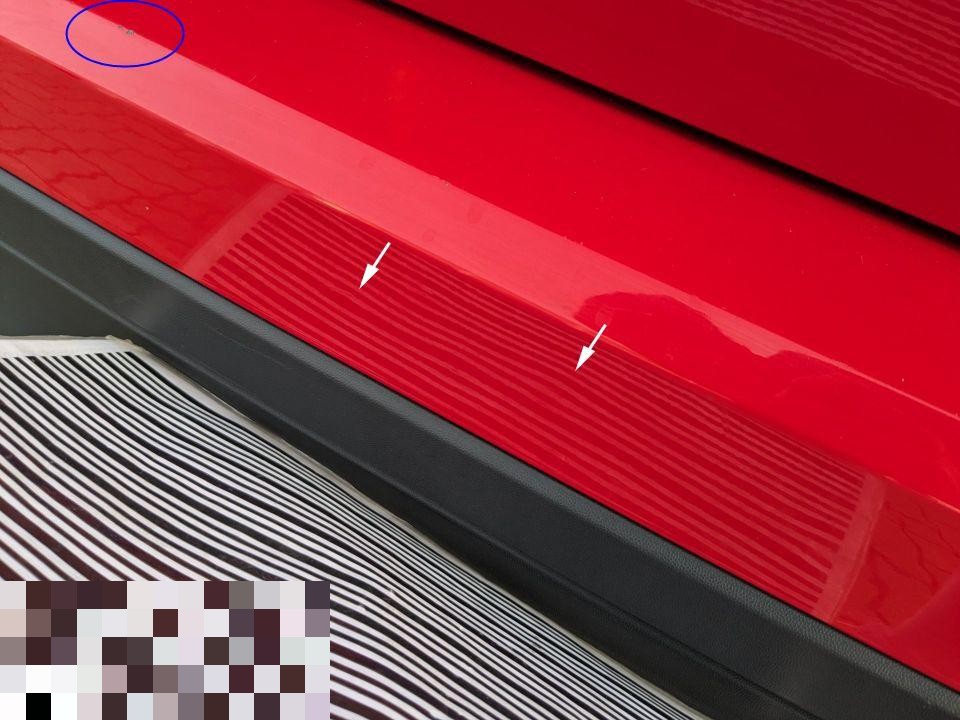 Detailaufnahme roter Einstiegsleiste/Schweller mit Kratzern, durch Pfeile markiert