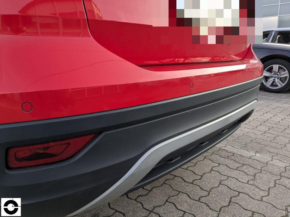 Heckansicht, roter SUV, Stoßfänger unten mit Einparksensoren, keine sichtbaren Schäden
