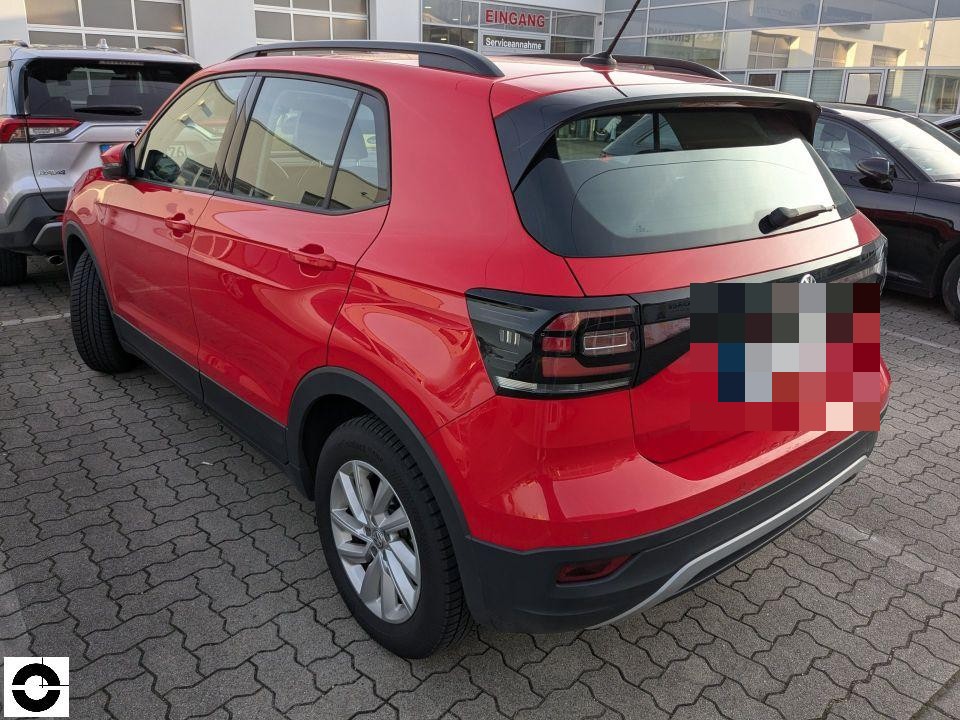 Heckansicht schräg links, roter Kompakt-SUV auf Parkplatz, kein Schaden sichtbar