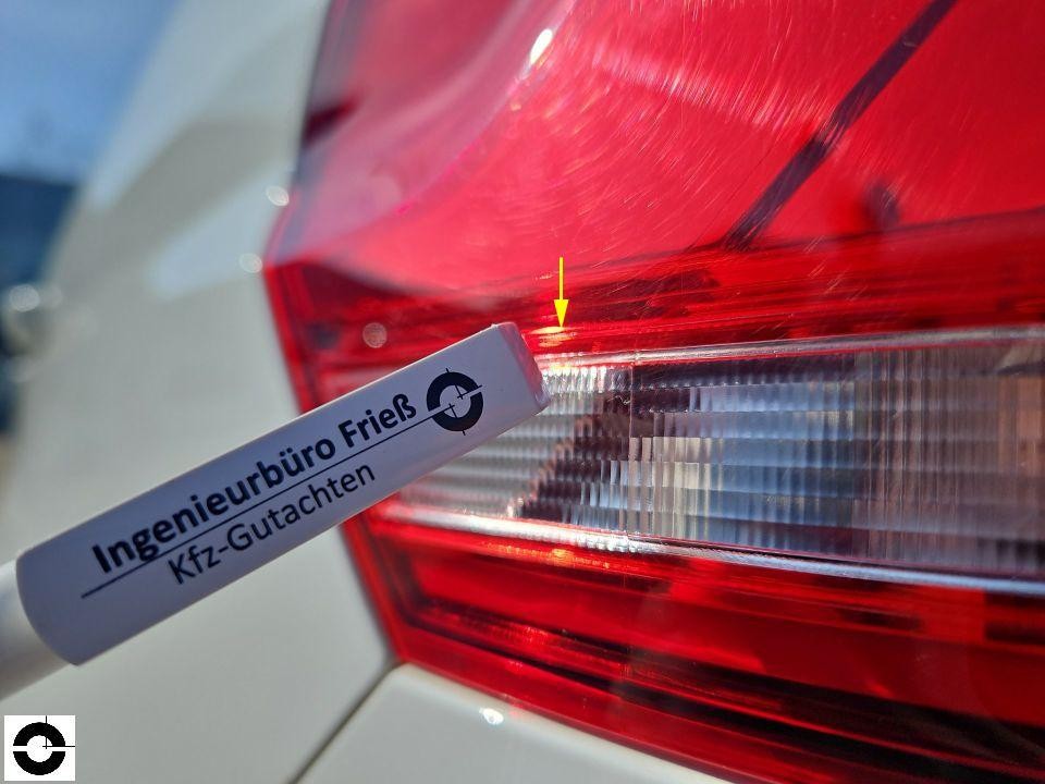 Detailaufnahme Rückleuchte rechts mit gelbem Pfeil auf Kratzer/Beschädigung