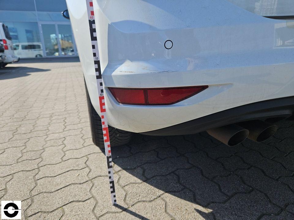 Heckschürze links mit Kratzspuren und Schmutz, Messlatte zur Schadendokumentation