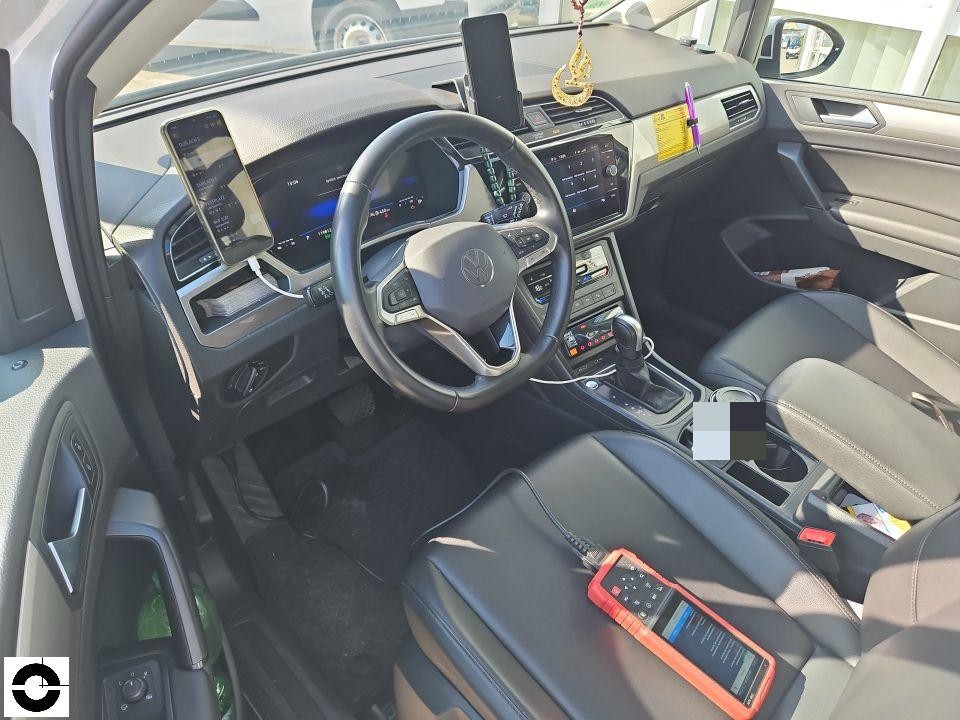 Innenraum-Ansicht, Fahrersitz mit Blick auf Armaturenbrett und Mittelkonsole, Diagnosegerät auf Beifahrersitz