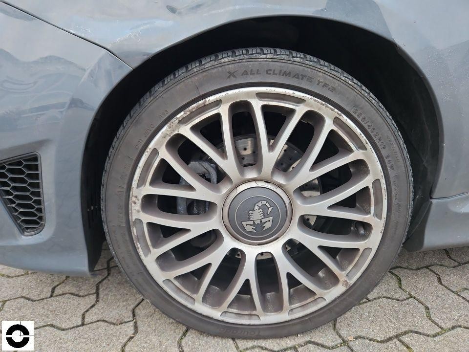 Detailaufnahme vorderes linkes Rad mit Abarth-Felge, Bordsteinschäden an Felge sichtbar