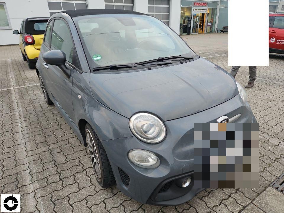Frontansicht, grauer Kleinwagen auf Parkplatz, keine sichtbaren Schäden