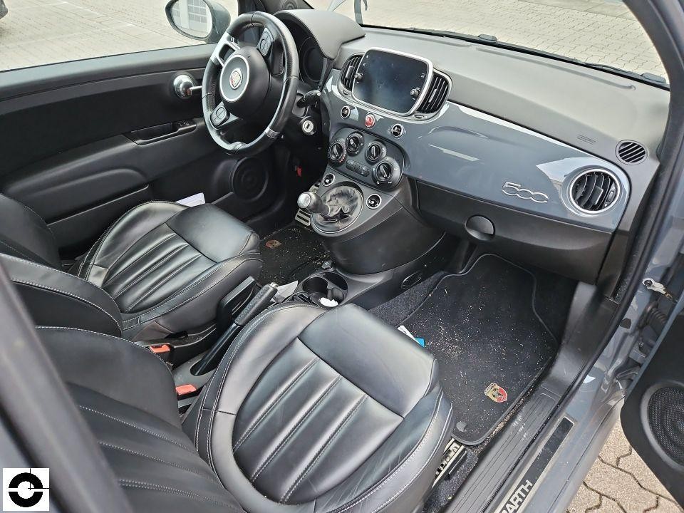 Innenraum Fahrerseite, schwarze Ledersitze, Armaturenbrett, Mittelkonsole, leichte Verschmutzung im Fußraum
