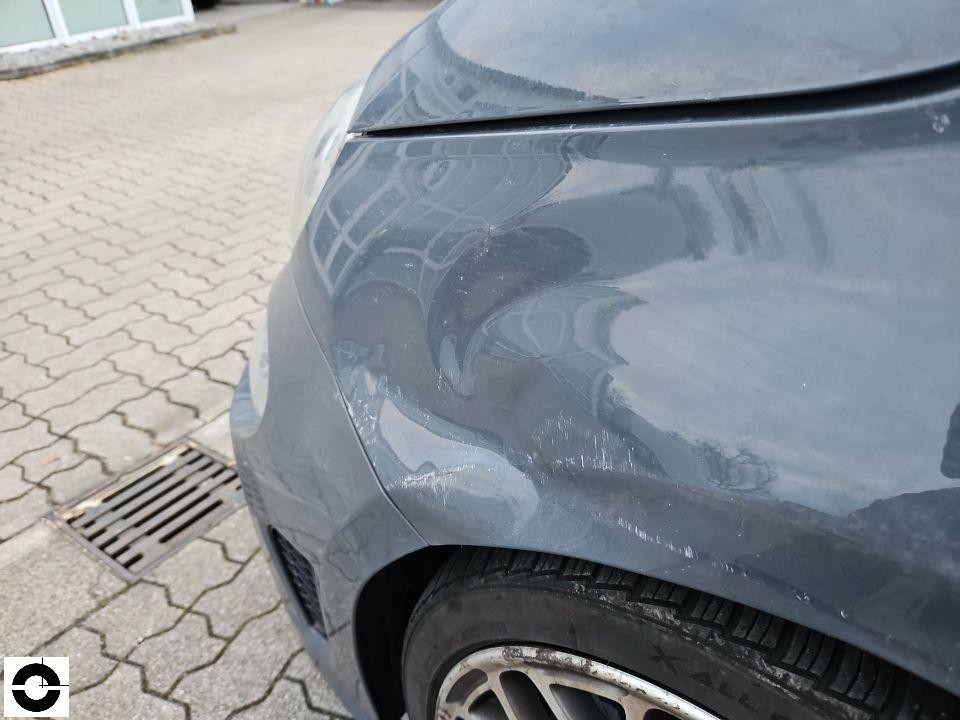 Vorderer Kotflügel links mit Kratzern und Schürfspuren an der Stoßstange