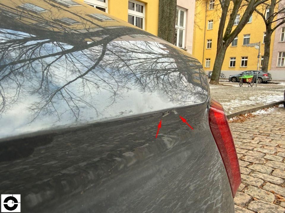 Heckdeckel mit Kratzern/Lackschäden, rote Pfeile markieren Schadenstellen, rechte Rückleuchte sichtbar