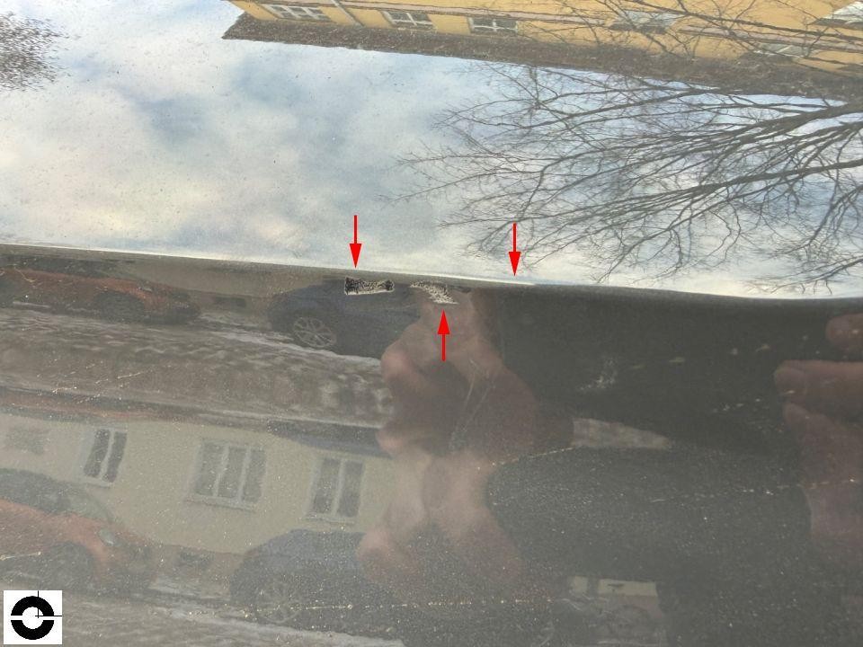 Nahaufnahme Dachkante mit Lackschäden und Kratzern, rote Markierungspfeile