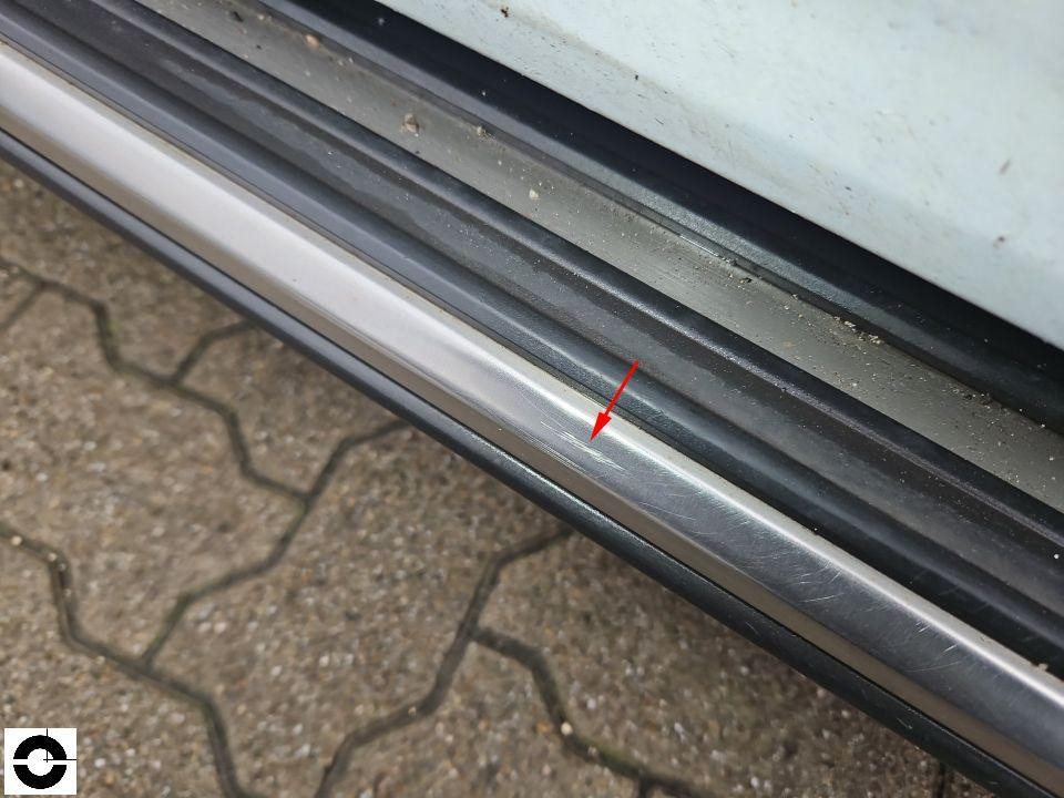 Einstiegsleiste mit Kratzern, roter Pfeil markiert Schadenstelle