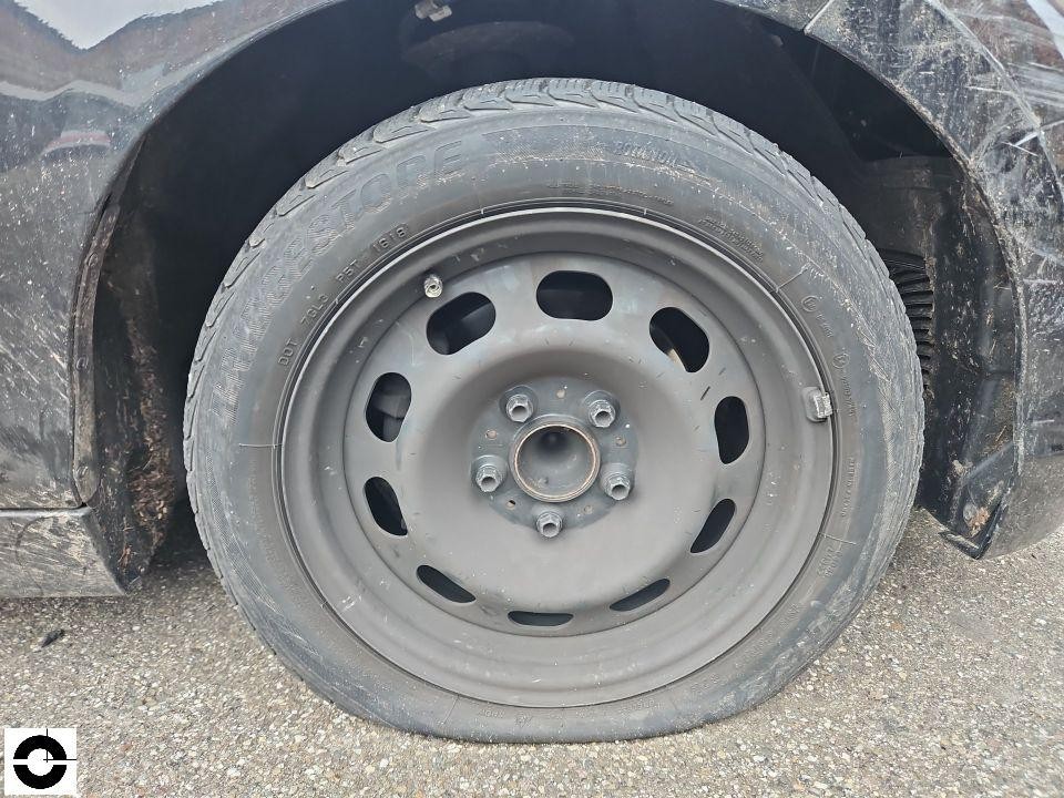 Detailaufnahme Rad hinten rechts, graue Stahlfelge mit Bridgestone-Reifen, verschmutzt