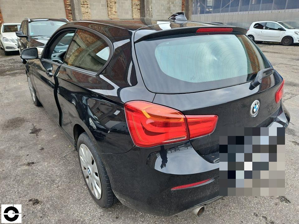 Heckansicht schräg links, schwarzer BMW 1er, Kennzeichen pixeliert, keine sichtbaren Schäden