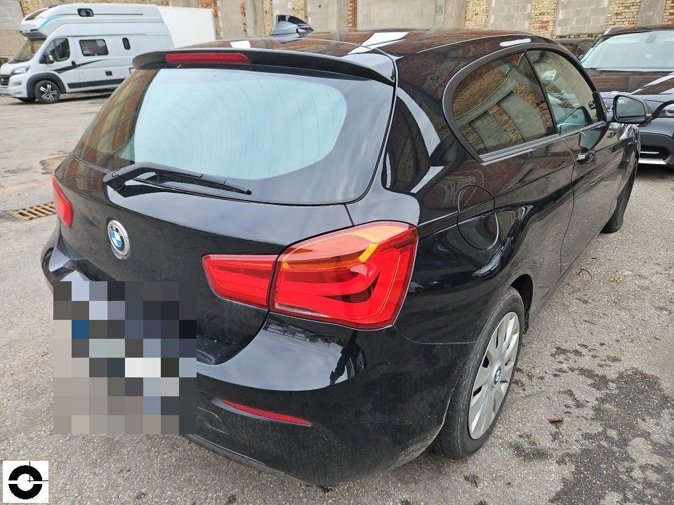 Heckansicht schräg rechts, schwarzer BMW 1er, Kennzeichen pixeliert, keine sichtbaren Schäden