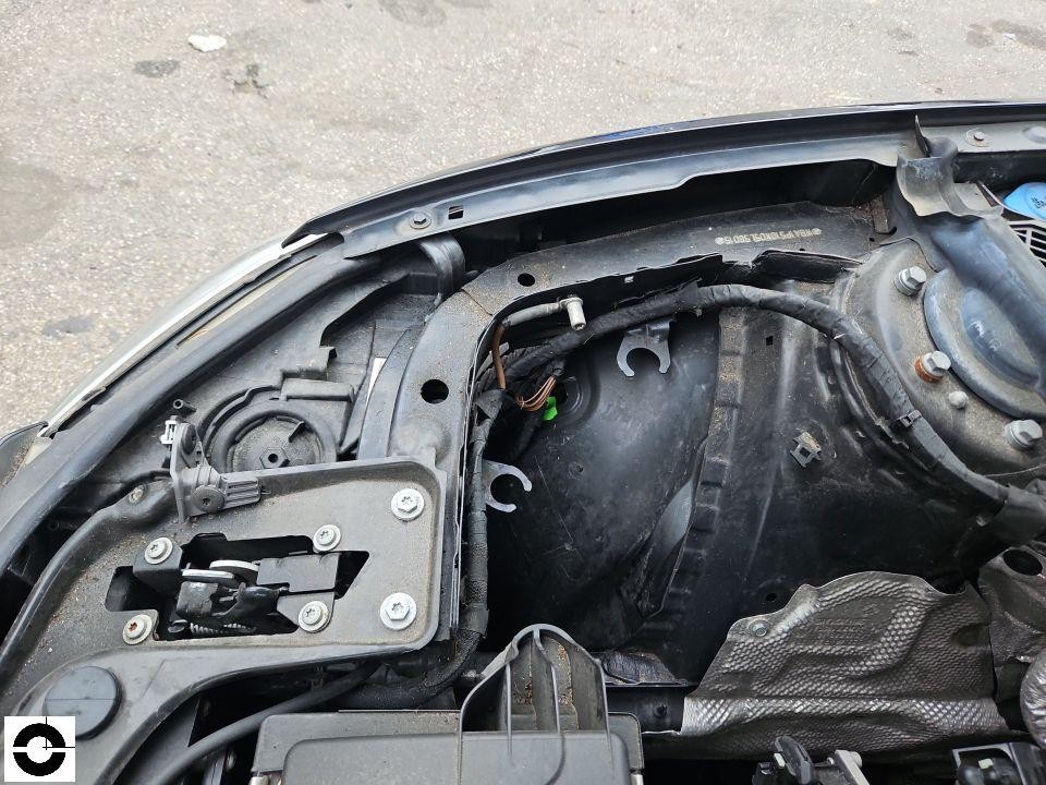 Motorraum vorne links, Scheinwerferaufnahme und Kabelstränge sichtbar, Frontschaden