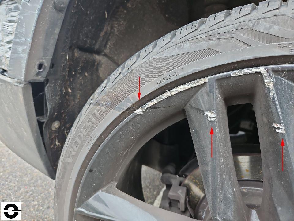 Detailaufnahme Alufelge mit Bordsteinschäden, rote Pfeile markieren Kratzer und Abschürfungen