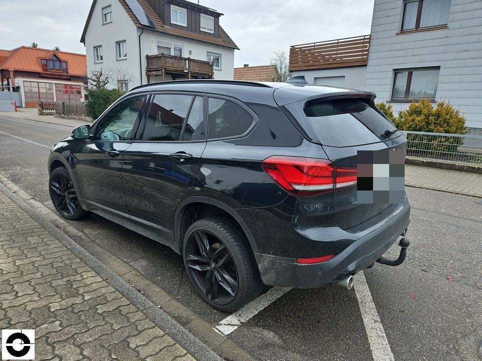 Heckansicht schräg links, schwarzes SUV mit Anhängerkupplung, keine sichtbaren Schäden