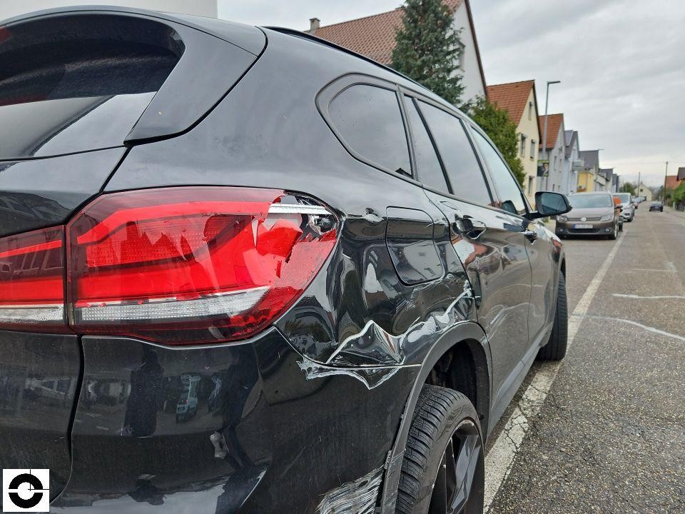 Heckansicht schräg rechts, deutlicher Unfallschaden am hinteren rechten Kotflügel mit Blechverformung und Lackabplatzungen