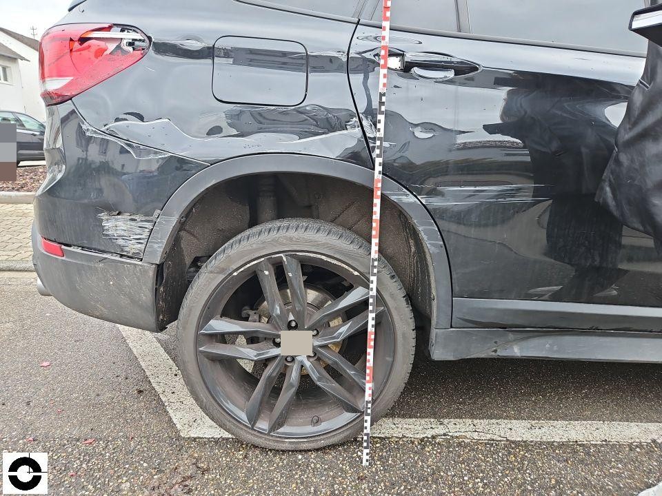 Hintere linke Seite mit starken Deformationen an Kotflügel und Stoßstange, Messlatte zur Dokumentation