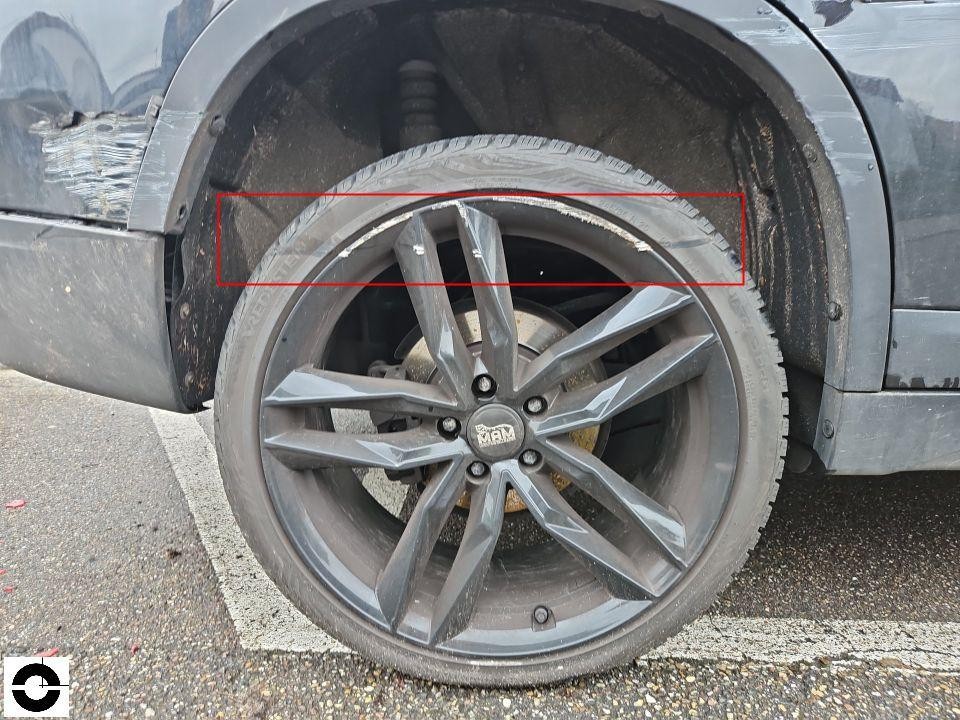 Vorderes rechtes Rad mit beschädigter Felge und Radlaufverkleidung, Unfallschaden sichtbar