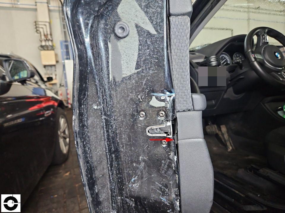 B-Säule rechts mit Gurthalterung, Lackschäden und Korrosionsschutz sichtbar, roter Pfeil markiert Bereich