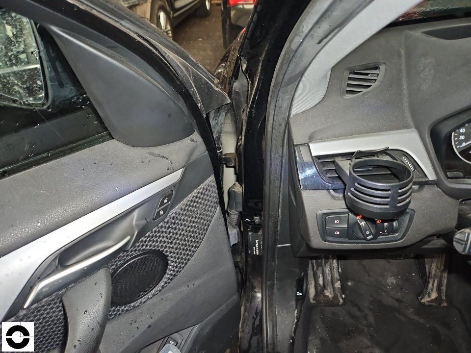 Blick durch geöffnete Fahrertür auf Armaturenbrett und A-Säule, schwerer Frontschaden sichtbar