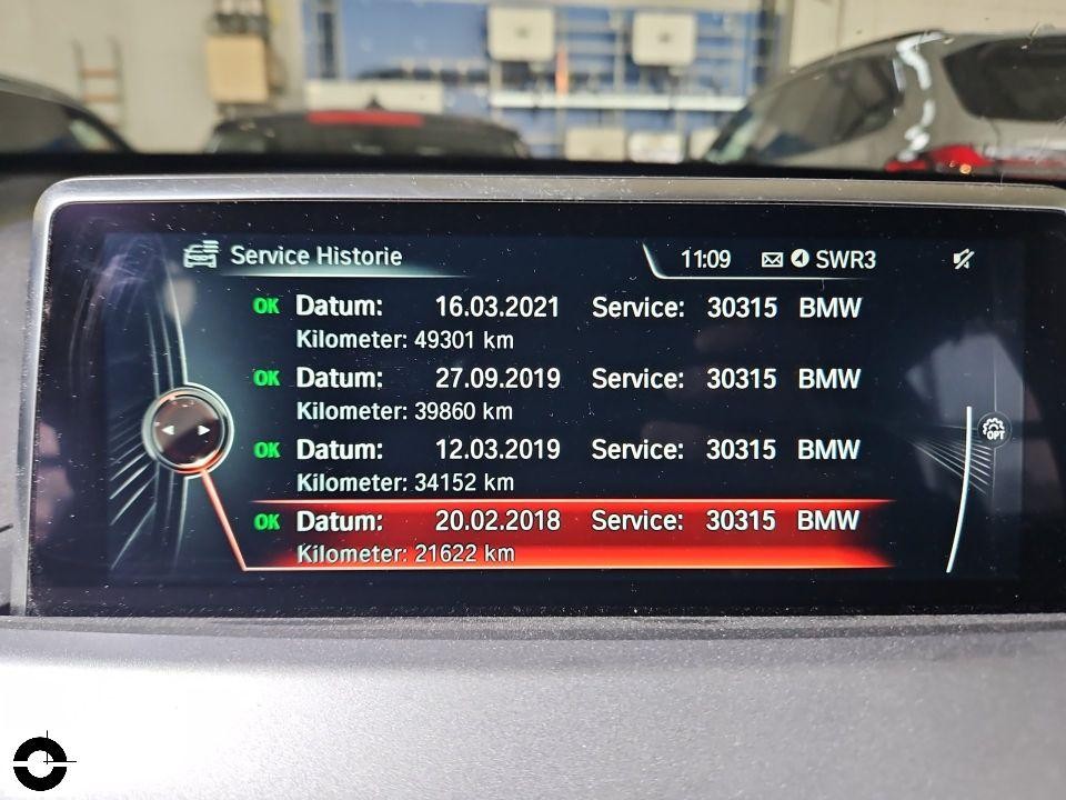 BMW iDrive Display zeigt Service-Historie mit Wartungsterminen und Kilometerständen