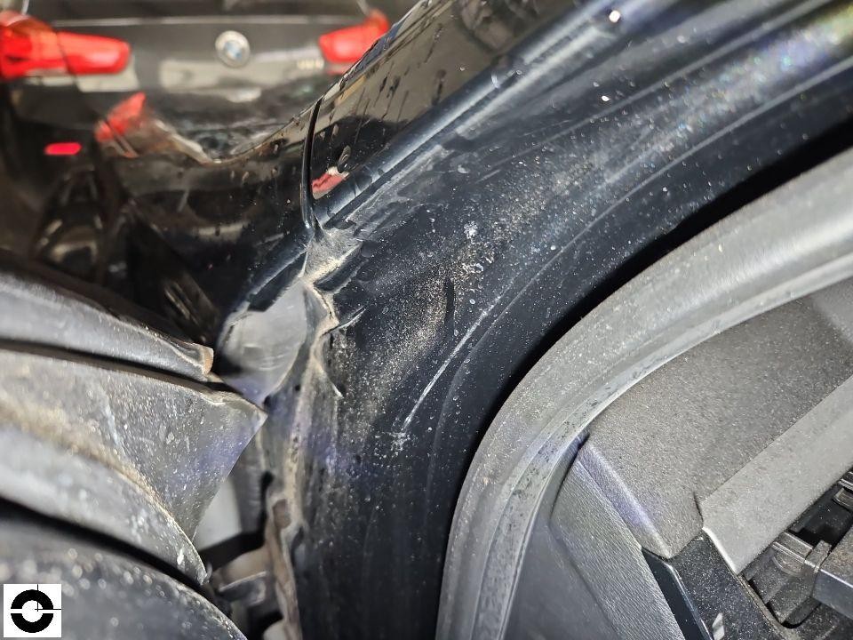 Detailaufnahme hinterer rechter Kotflügel mit Deformation und Lackkratzern