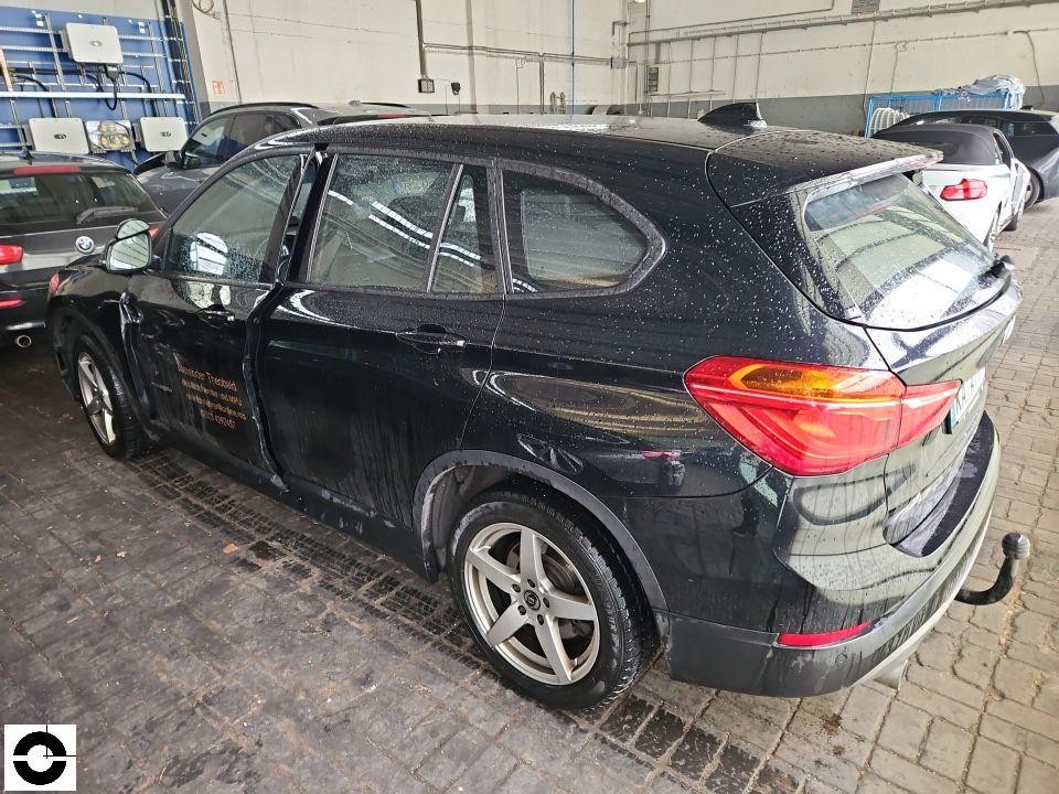 Heckansicht schräg rechts, nasses Fahrzeug mit Firmenbeschriftung auf Tür, Anhängerkupplung sichtbar