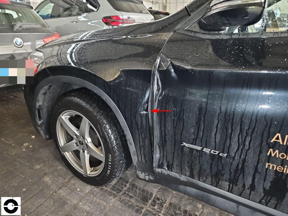 Hintere linke Seitenwand mit deutlichen Kratzern und Lackschäden, roter Pfeil markiert Schadenstelle
