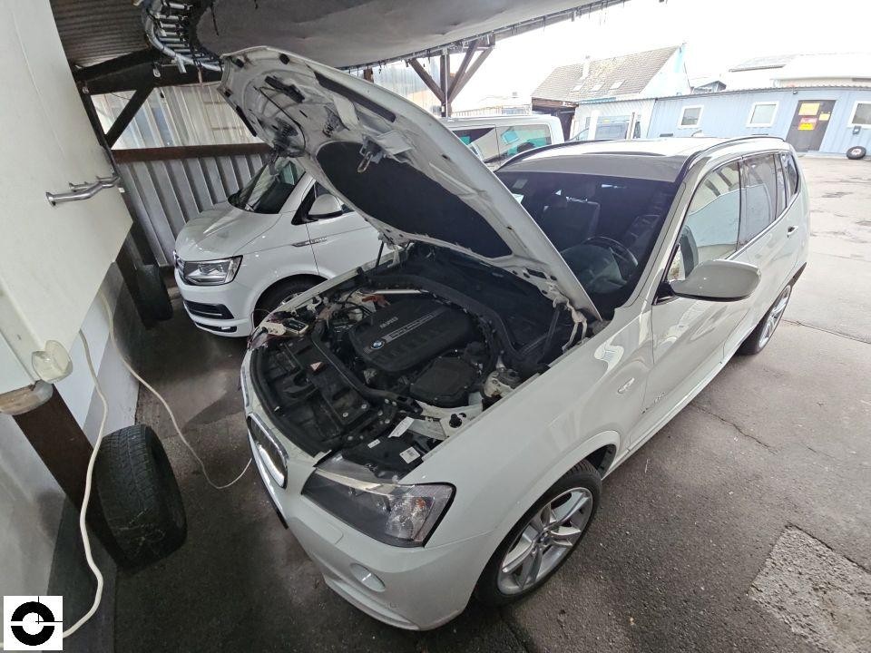 Frontansicht mit geöffneter Motorhaube, Motorraum sichtbar, Werkstattgelände