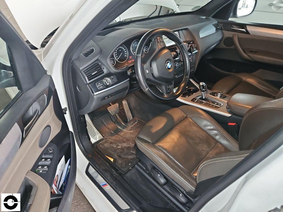 Innenraum Fahrerseite, geöffnete Tür, Ledersitze braun, Armaturenbrett und Lenkrad sichtbar