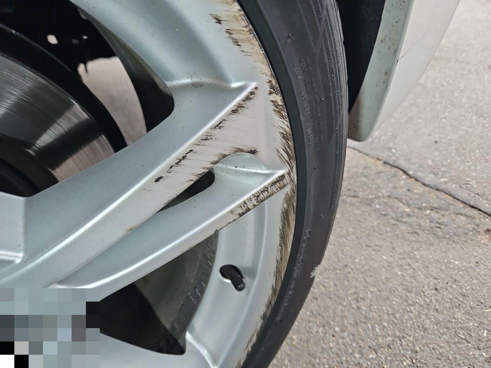 Nahaufnahme Alufelge mit starken Kratzern und Schürfspuren am Felgenrand