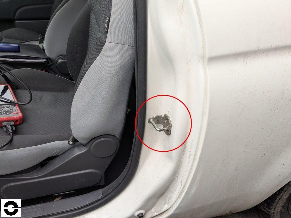 B-Säule links mit Türfangöse, roter Kreis markiert Bereich, Diagnosegerät auf Fahrersitz