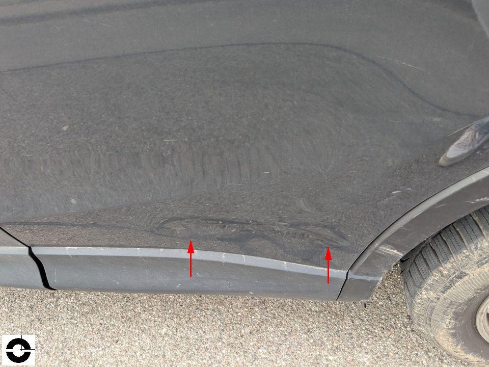 Detailaufnahme Seitenschweller links mit Kratzern und Schürfspuren, rote Pfeile markieren Schaden