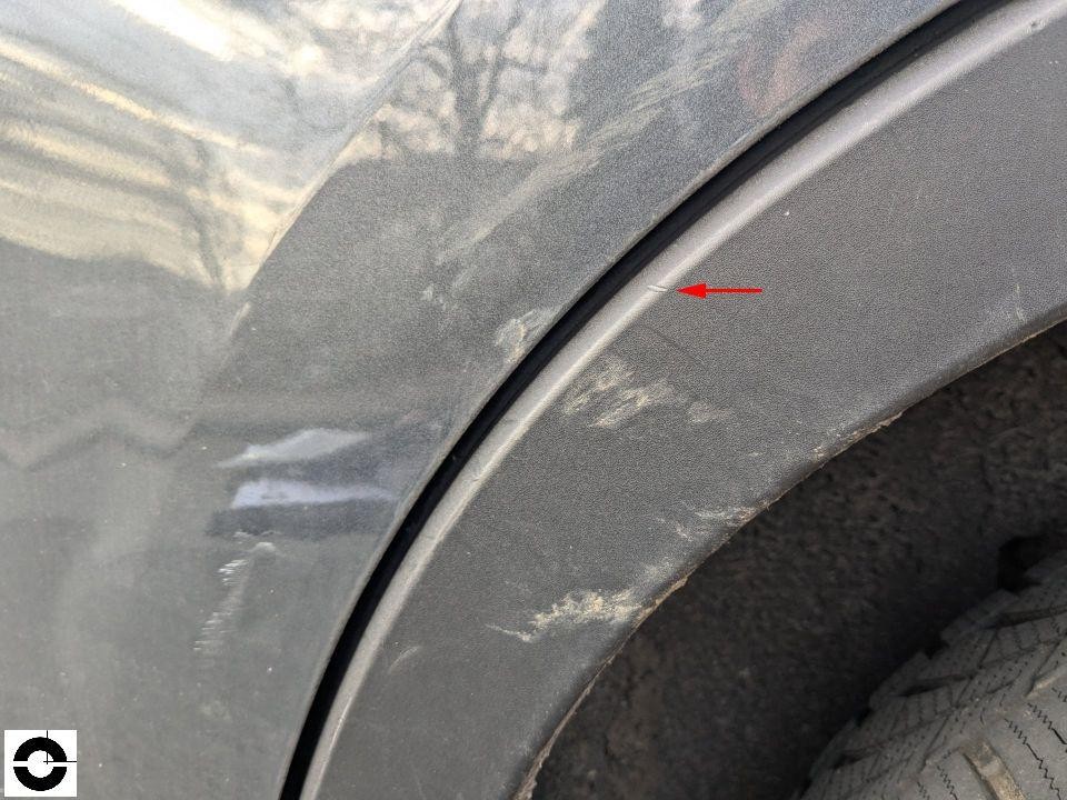 Radlauf hinten rechts mit Kratzern und Schürfspuren, roter Markierungspfeil