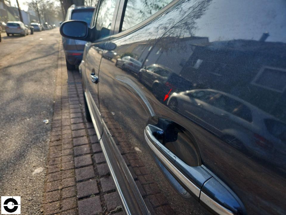 Seitenansicht linke Fahrzeugseite, Kratzer an hinterer Tür mit rotem Pfeil markiert