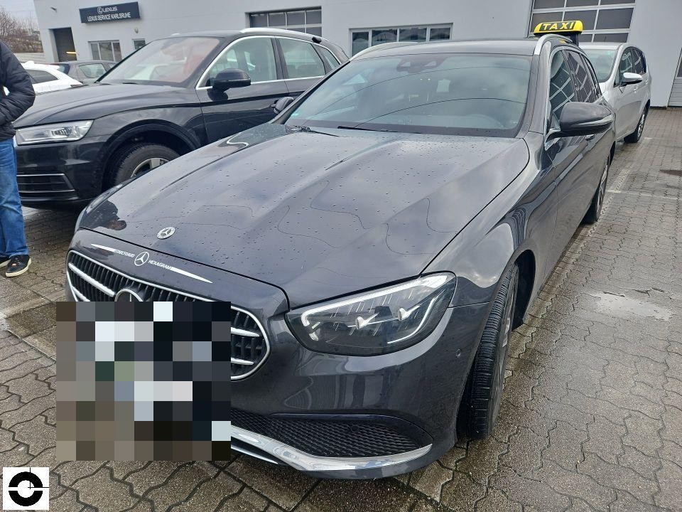 Frontansicht, dunkelblauer Kombi mit Taxischild, nasse Motorhaube, Parkplatz