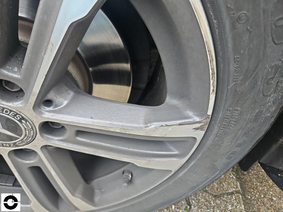 Nahaufnahme Mercedes-Alufelge mit Bordsteinschaden und Kratzern an der Speiche