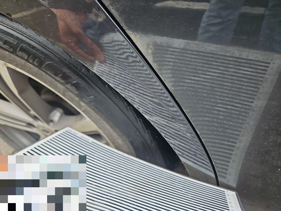 Nahaufnahme Radlauf und Kotflügel vorne links mit Kratzern und Lackkontakt