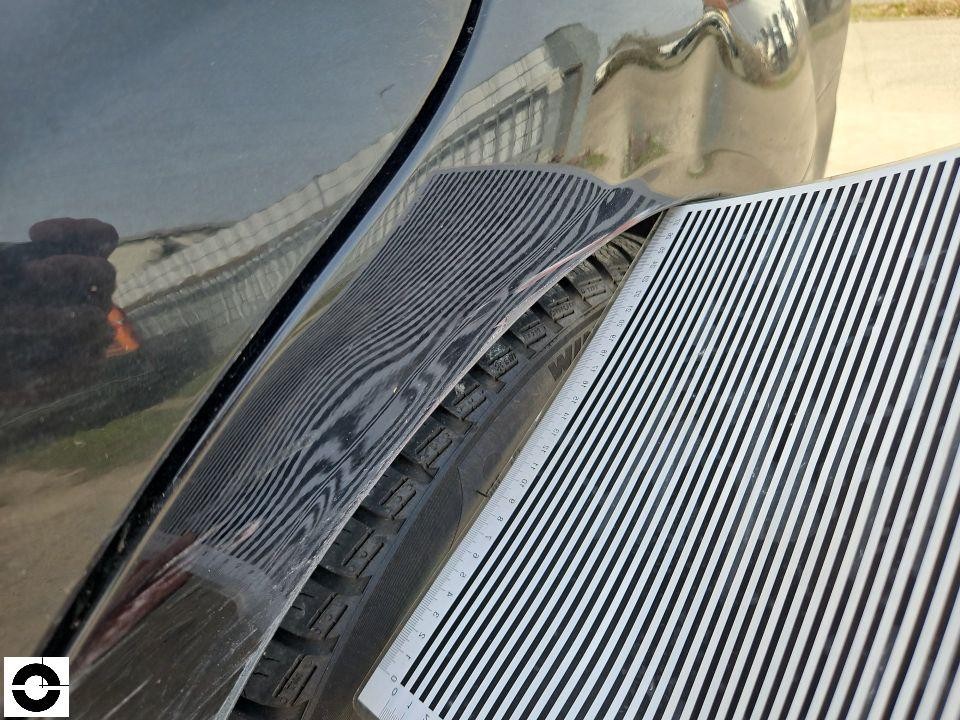 Detailaufnahme Delle an Motorhaube mit Linienreflektor und Maßstab zur Schadendokumentation