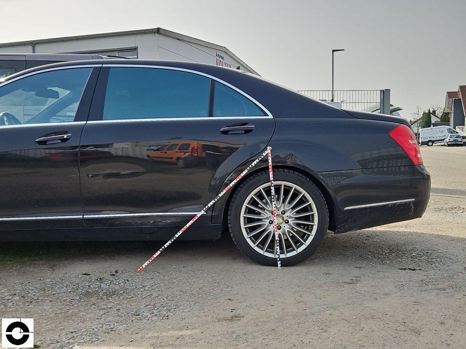 Seitenansicht hinten rechts mit Messlatte am Hinterrad, schwarze Limousine