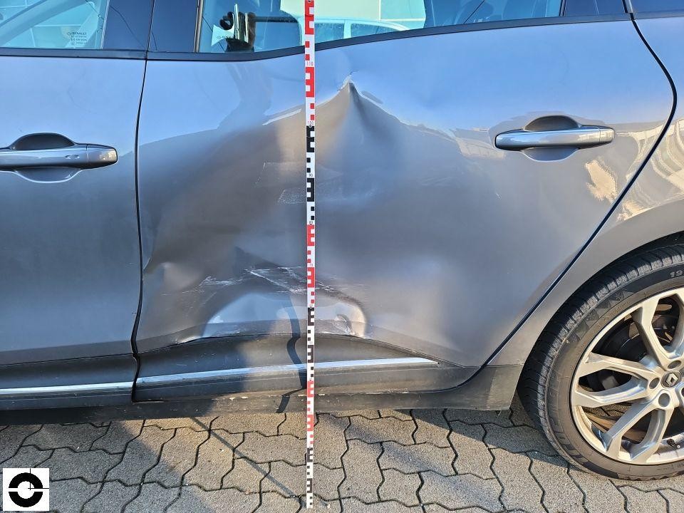 Seitenansicht linke Seite, massive Einbeulung an hinterer Tür und Schweller, Messlatte zur Schadensdokumentation