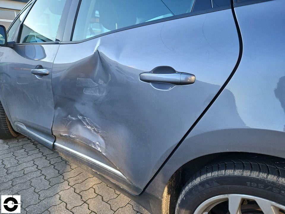 Seitenschaden an hinterer linker Tür mit starker Delle und Lackabplatzungen
