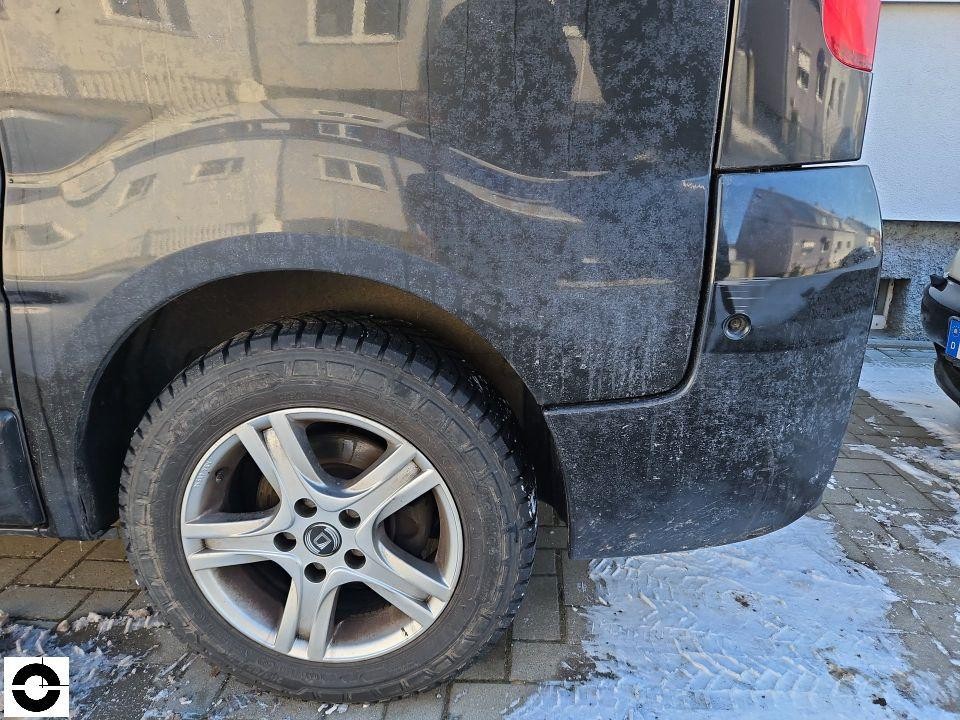 Hintere linke Ecke, Stoßstange mit Schmutz und leichten Kratzern, Winterreifen sichtbar