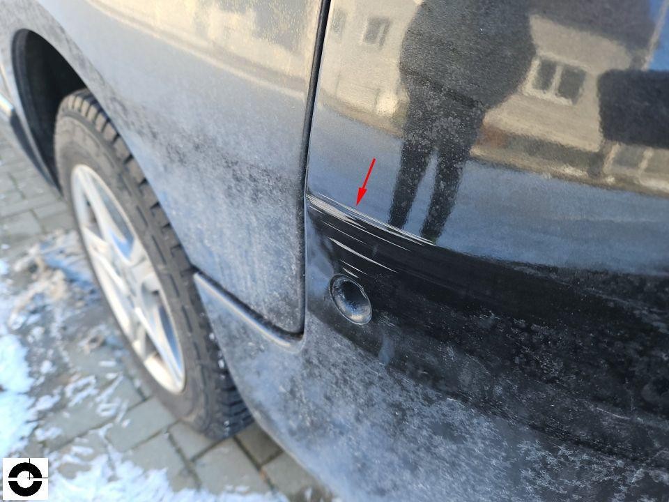 Hintere rechte Tür mit Kratzern und Schürfspuren, roter Pfeil markiert Schaden
