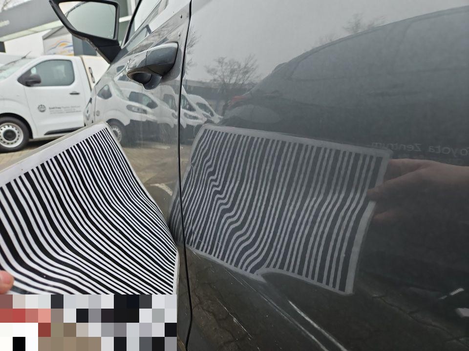 Dellenprüfung mit Streifenlichtreflektor an hinterer linker Tür, Delle sichtbar