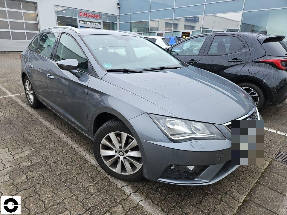 Frontansicht schräg von rechts, grauer Kombi auf Werkstattgelände, keine sichtbaren Schäden