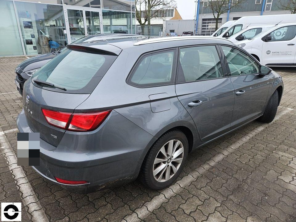 Heckansicht schräg rechts, grauer Kombi auf Parkplatz, keine sichtbaren Schäden