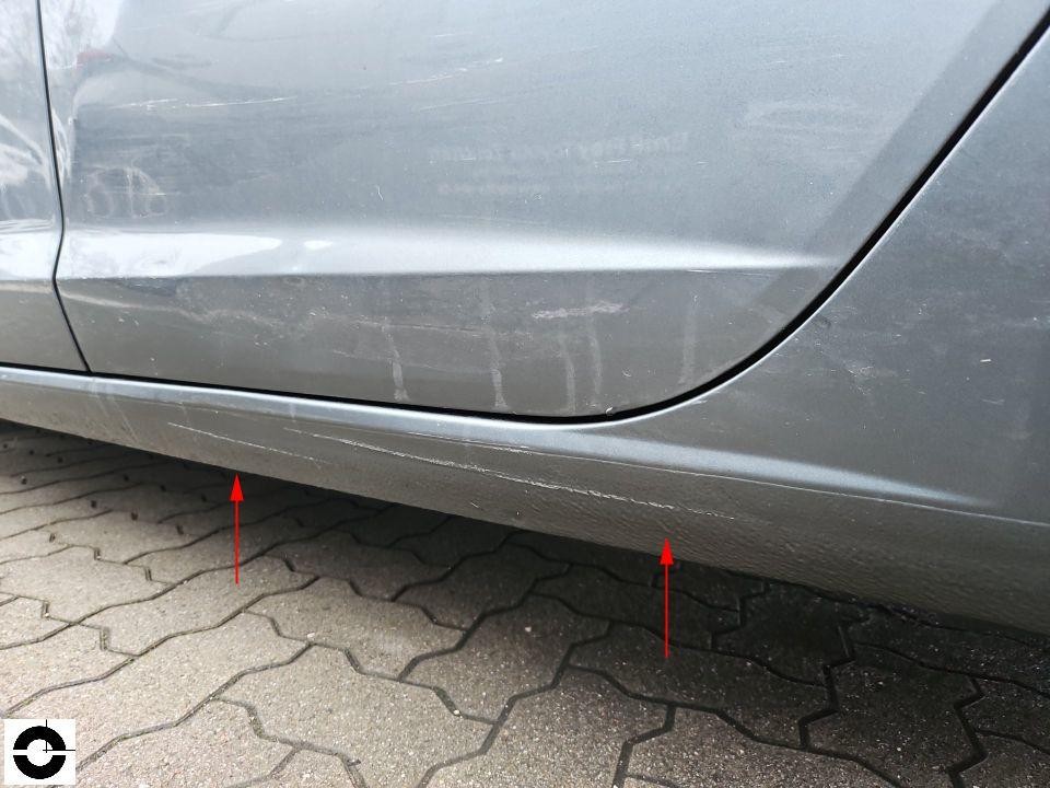 Seitenschweller links mit Kratzern und Lackschäden, rote Pfeile markieren Schadenstellen