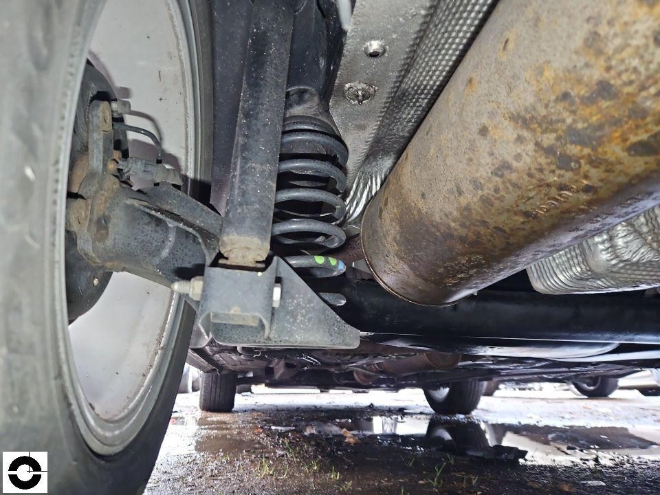 Unterboden-Ansicht, hintere Achse mit Stoßdämpfer, Auspuffanlage mit Korrosion sichtbar