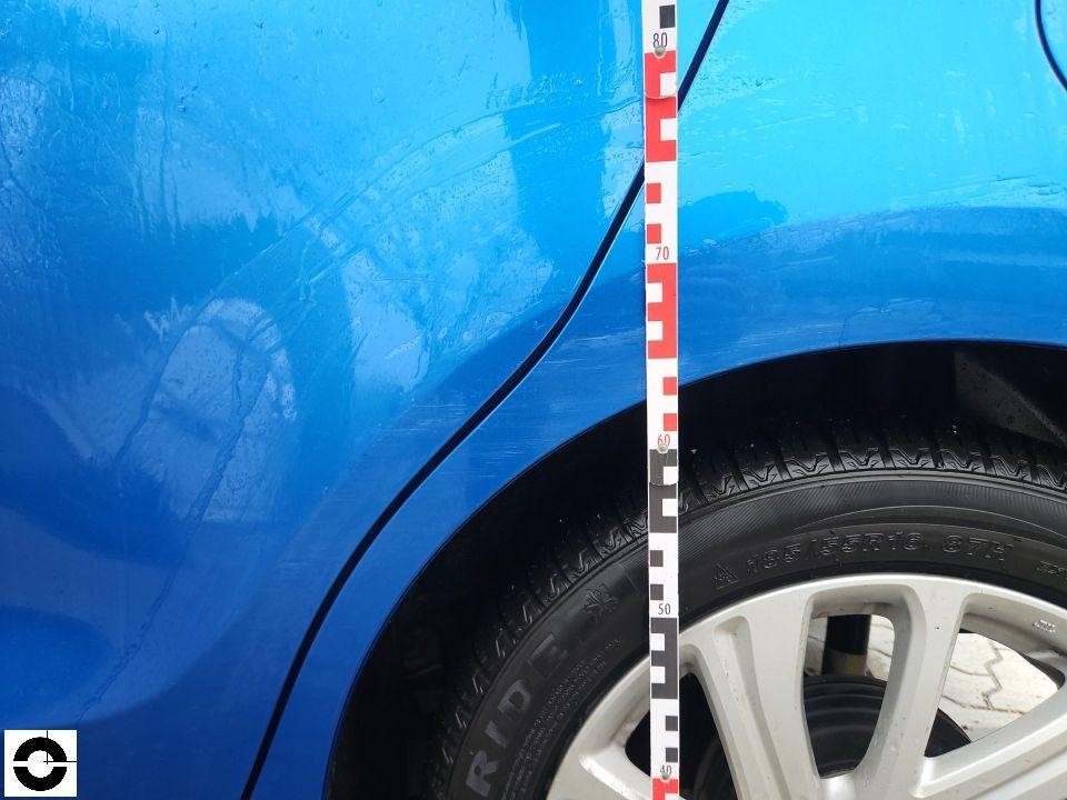 Detailaufnahme hinterer Kotflügel links mit Messlatte, Kratzer und Schürfspuren sichtbar